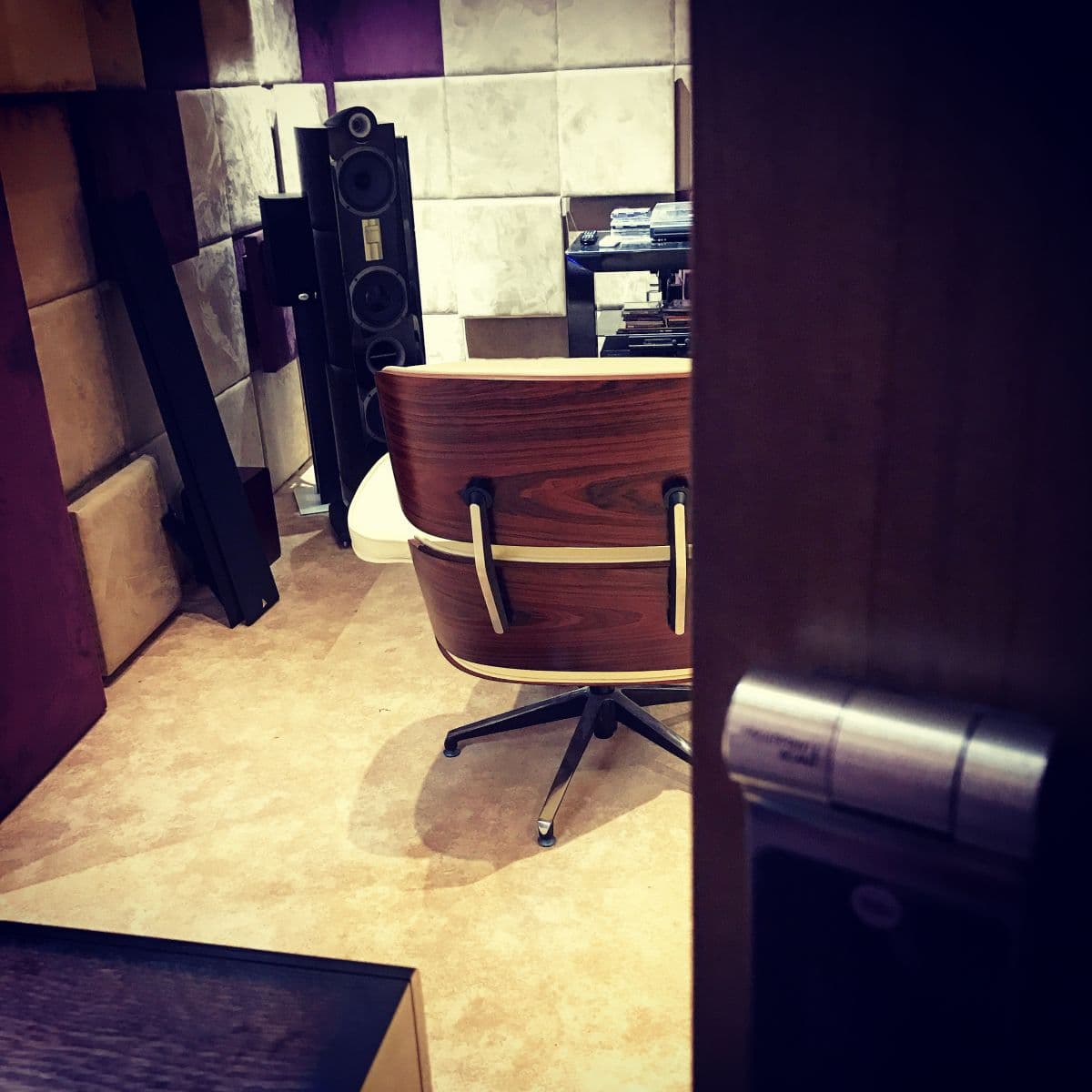 Eames lounge chair beside floorstanding speakers in the listening room