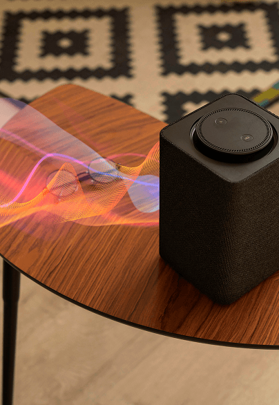 Speaker on a wooden table with colorful light trails